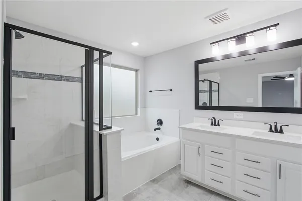 a bathroom with a double vanity sink mirror double and bathtub