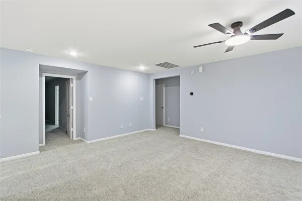 an empty room with closet and fan