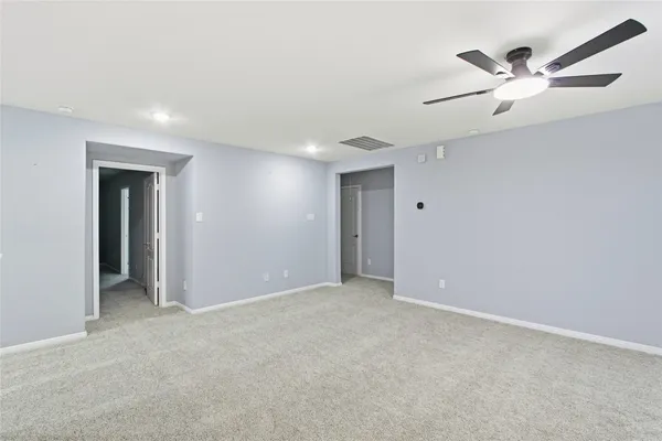 an empty room with closet and fan