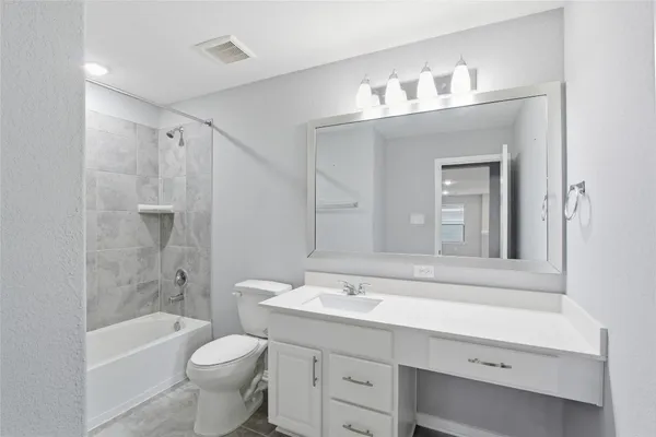 a bathroom with a sink a toilet a mirror and shower