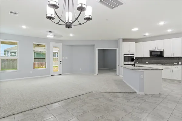 a kitchen with granite countertop a stove a sink and a refrigerator