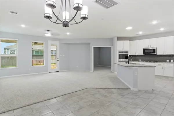 a kitchen with granite countertop a stove a sink and a refrigerator