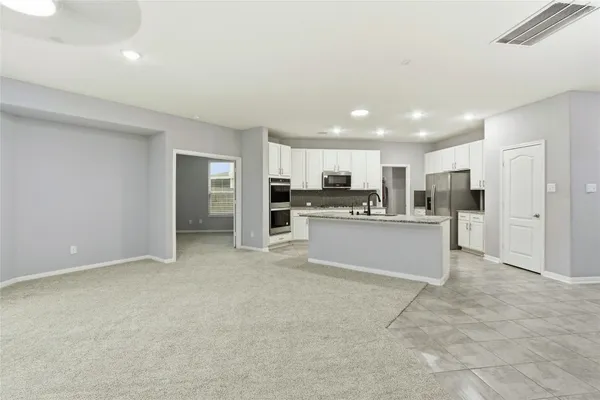 a view of kitchen with refrigerator sink microwave and cabinets