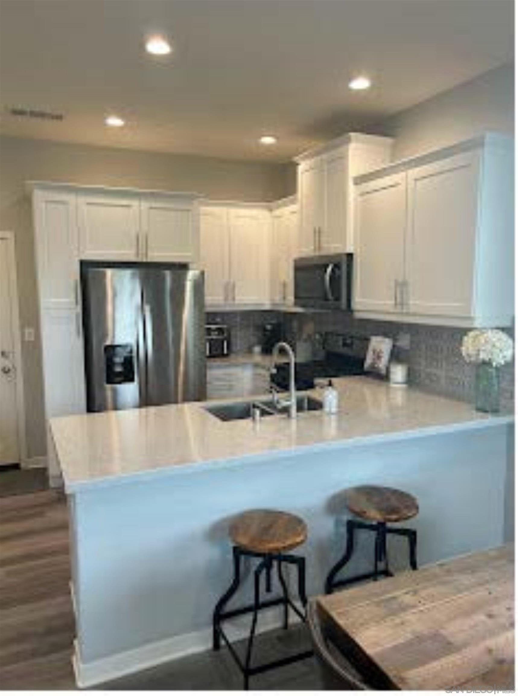 a large kitchen with kitchen island a table and chairs in it