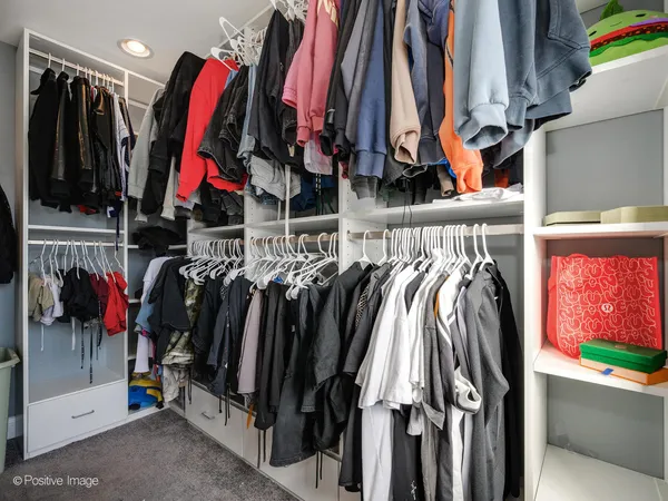 a view of walk in closet with clothes
