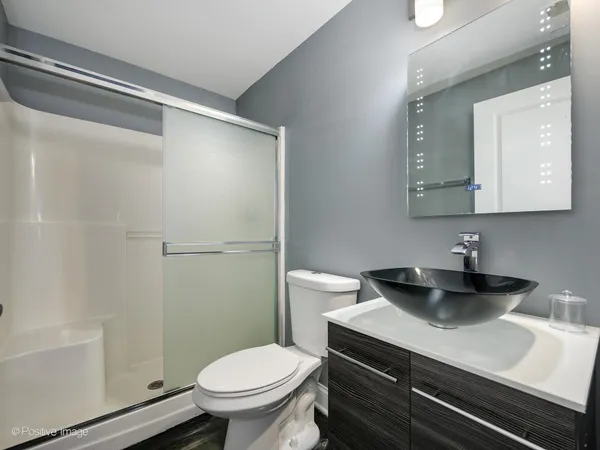 a bathroom with a sink a toilet a mirror and shower