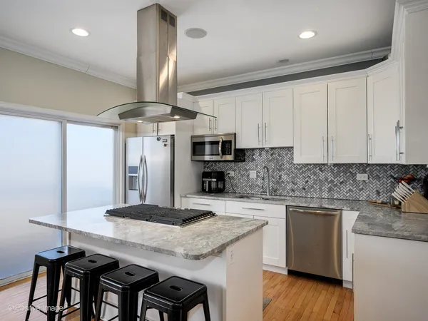 a kitchen with stainless steel appliances granite countertop a sink a stove and a refrigerator