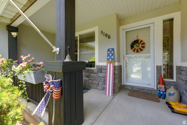 5196 Rodeo Circle Oakley, UT 84055 - Photo 6 of 57 Covered front porch featuring a concrete pad, dark-toned support pillars, and stone veneer accents