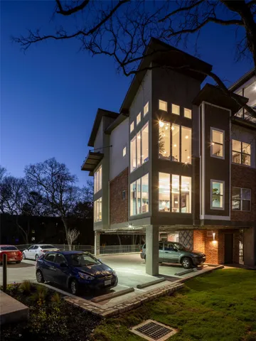 a kitchen with stainless steel appliances kitchen island granite countertop a dining table chairs and a refrigerator