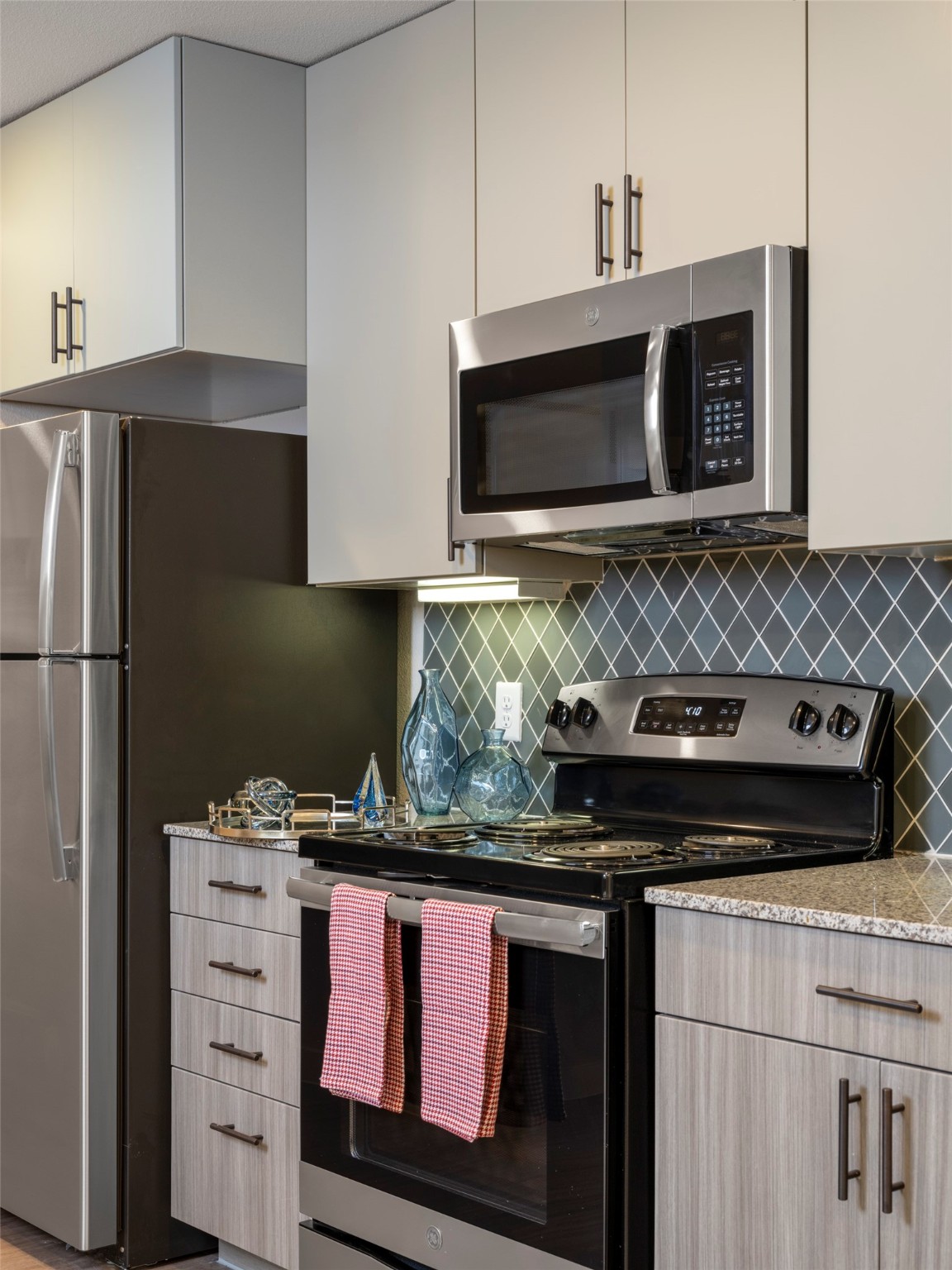1800 South Interstate 35 Frontage Road Austin, TX 78704 - Photo 28 of 36 a kitchen with stainless steel appliances granite countertop a stove and a microwave with cabinets