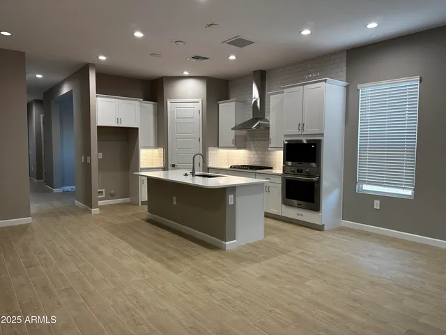 a kitchen with stainless steel appliances kitchen island granite countertop a refrigerator a sink and a stove