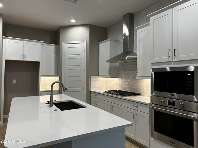 a kitchen with kitchen island a sink stainless steel appliances and cabinets
