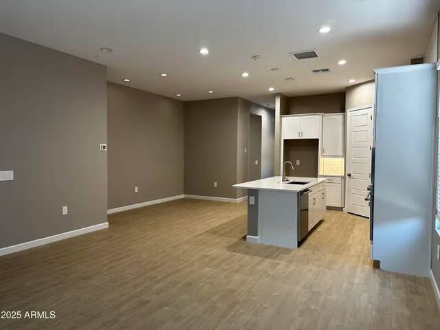a view of a kitchen with kitchen island stainless steel appliances a sink and a stove