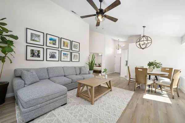 a living room with furniture a dining table and a chandelier