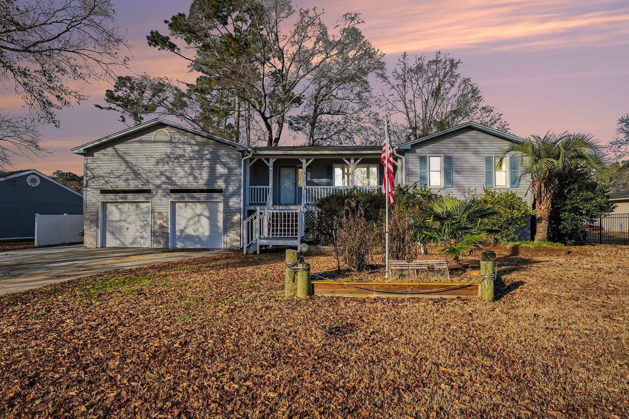 View of front facade with concrete driveway, covered porch, and a garage