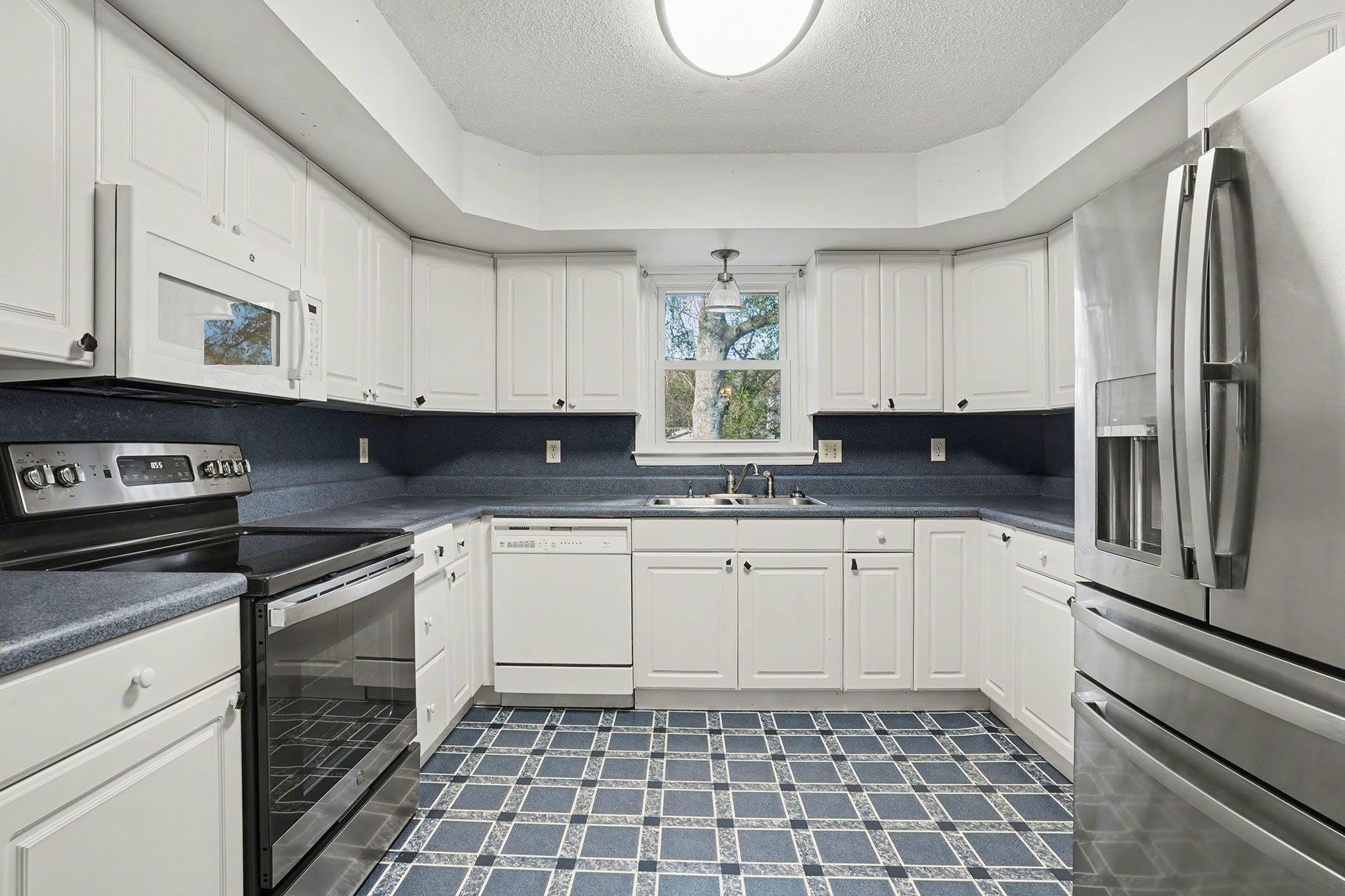 152 Brookgate Drive Myrtle Beach, SC 29579 - Photo 10 of 35 Kitchen featuring stainless steel appliances, dark countertops, dark floors, white cabinetry, and a textured ceiling