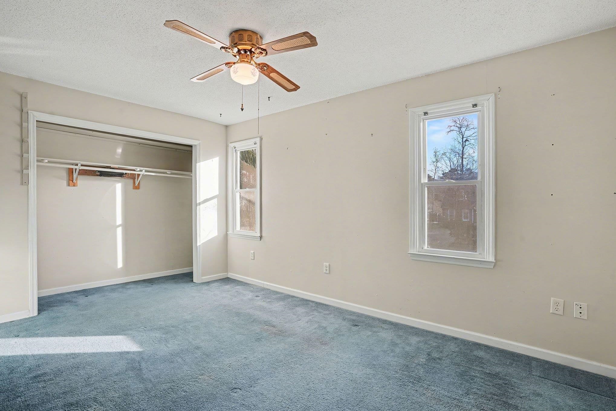 152 Brookgate Drive Myrtle Beach, SC 29579 - Photo 11 of 35 Unfurnished bedroom with multiple windows, a textured ceiling, carpet, a ceiling fan, and a closet