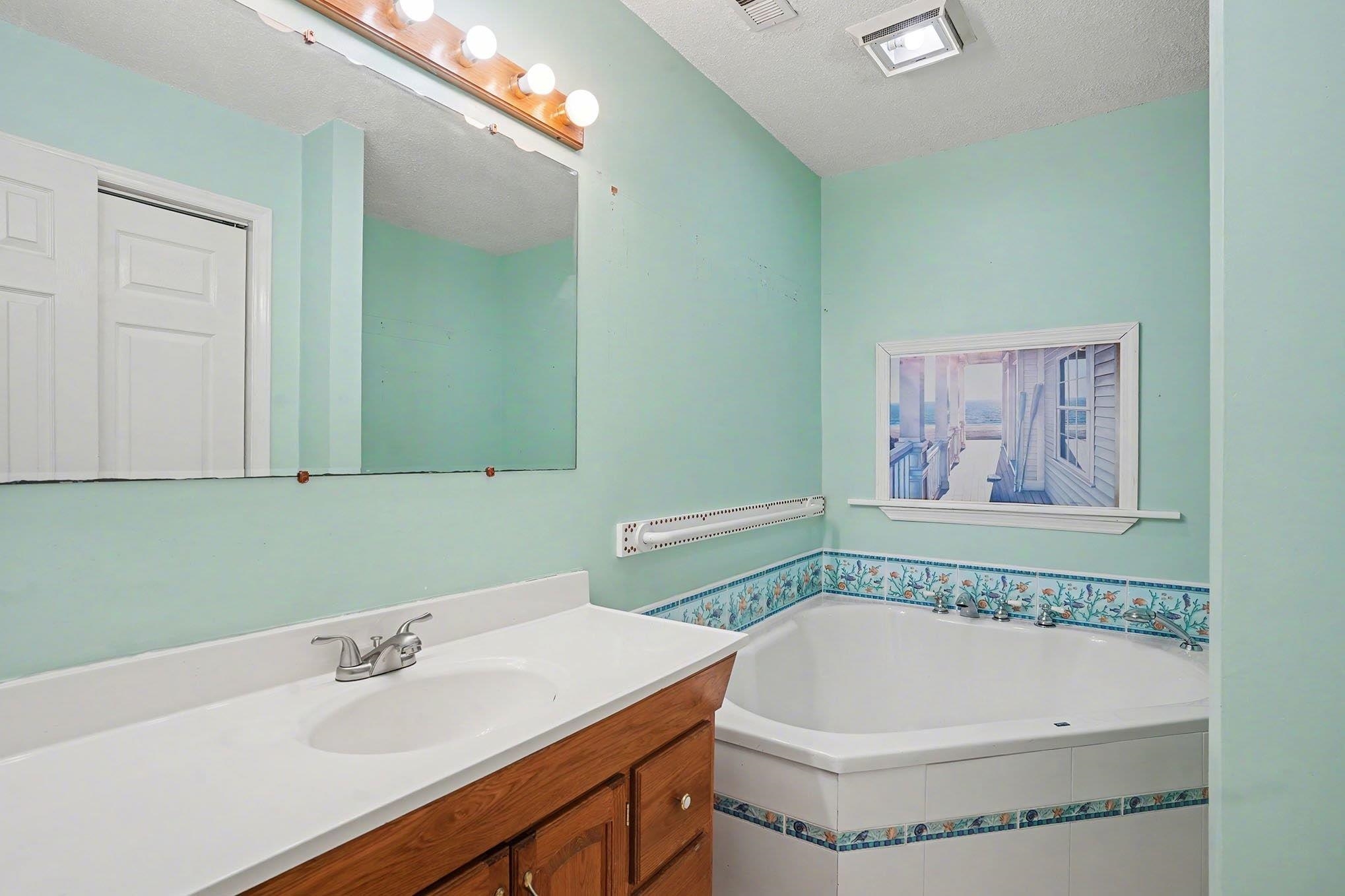 152 Brookgate Drive Myrtle Beach, SC 29579 - Photo 21 of 35 Bathroom with vanity, a garden tub, and a textured ceiling