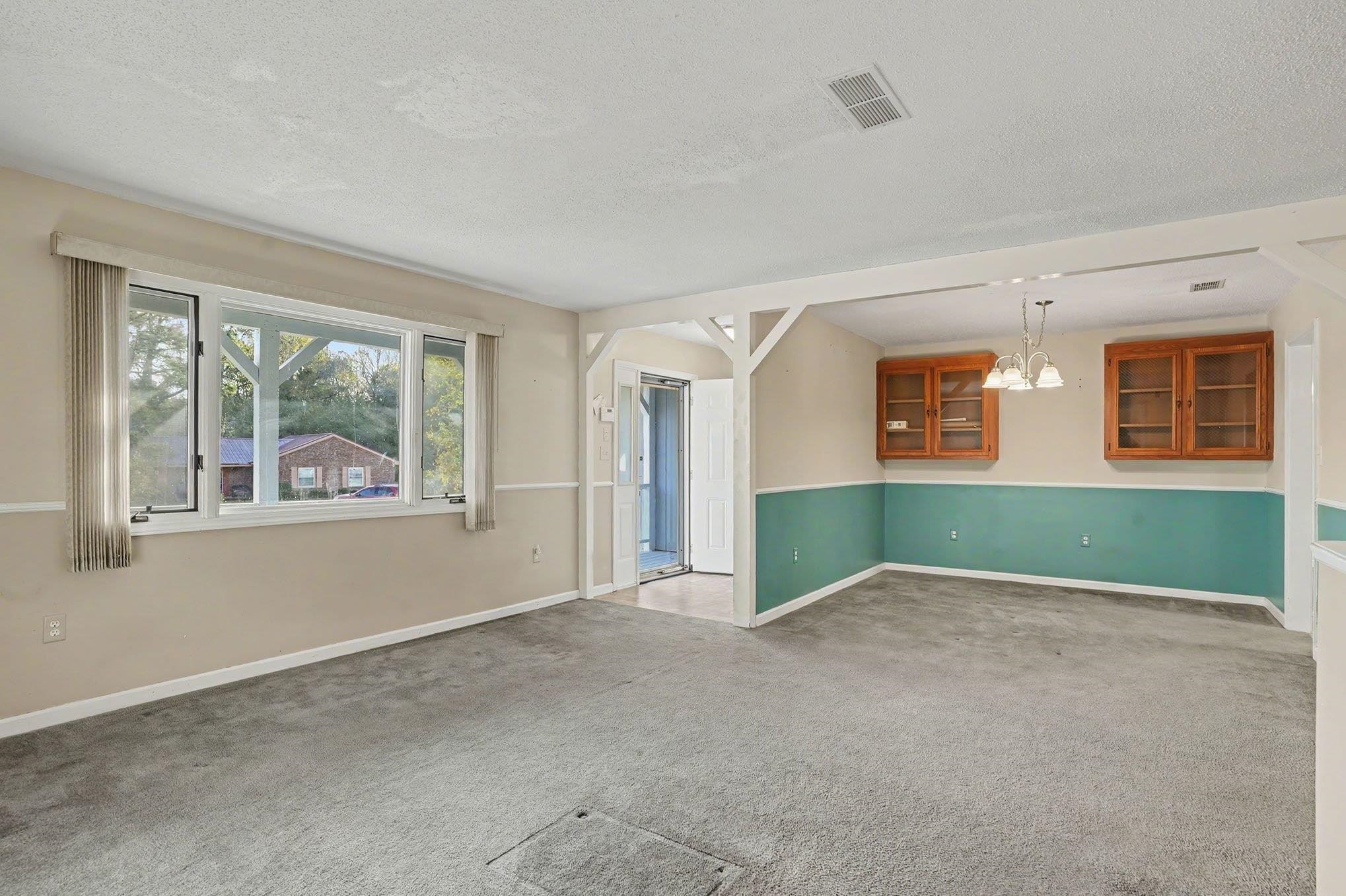 152 Brookgate Drive Myrtle Beach, SC 29579 - Photo 3 of 35 Empty room with a textured ceiling, carpet floors, and a chandelier