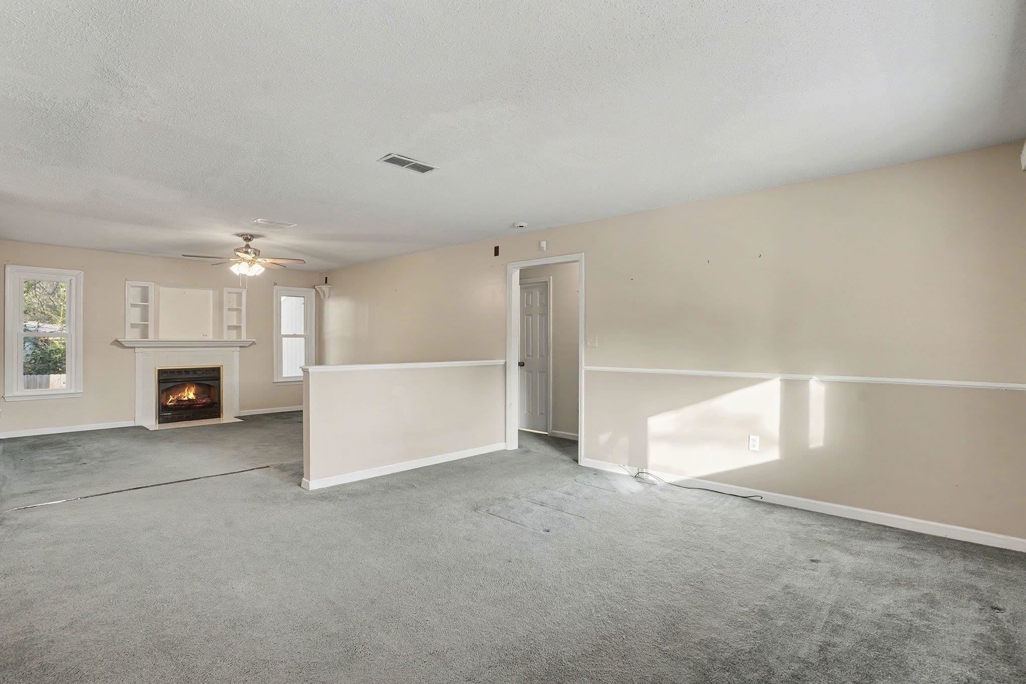 152 Brookgate Drive Myrtle Beach, SC 29579 - Photo 5 of 35 Unfurnished living room featuring carpet, a fireplace with flush hearth, a textured ceiling, and ceiling fan