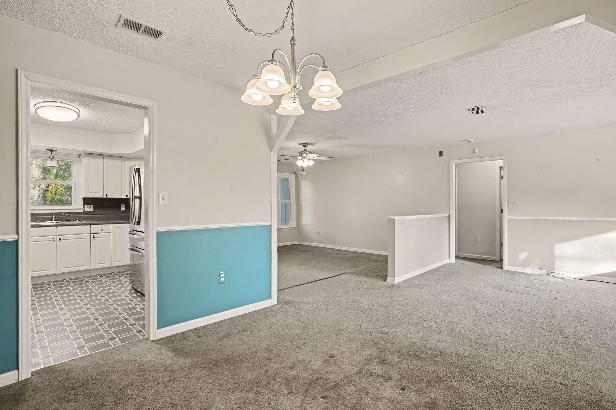 152 Brookgate Drive Myrtle Beach, SC 29579 - Photo 9 of 35 Empty room with a textured ceiling, light colored carpet, a chandelier, and ceiling fan