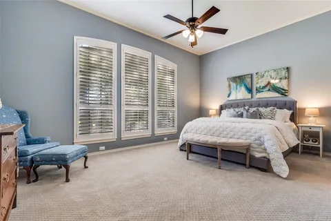 a spacious bedroom with a bed and a chandelier