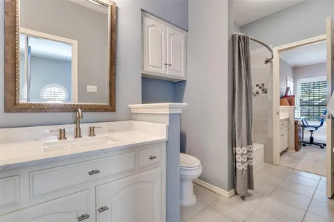a bathroom with a granite countertop sink mirror vanity and toilet