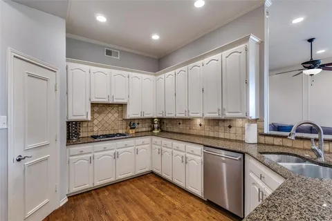 a kitchen with stainless steel appliances granite countertop a sink stove and cabinets