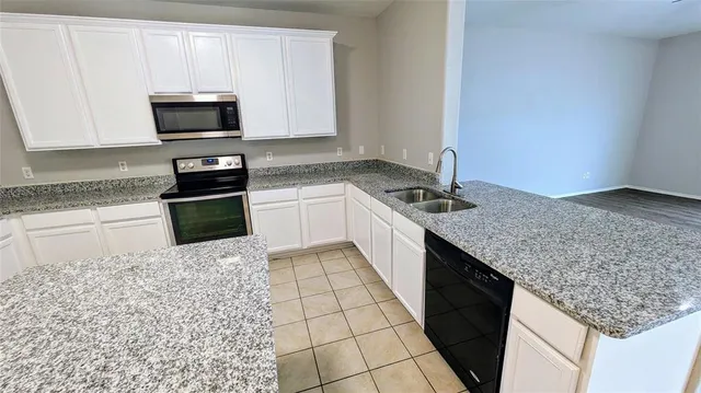 a kitchen with stainless steel appliances granite countertop a sink stove and microwave