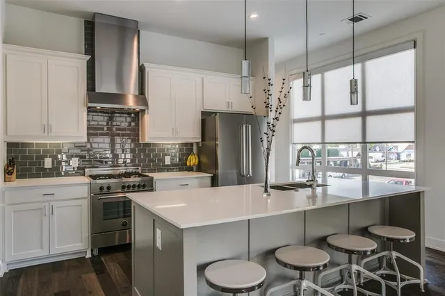 a kitchen with a sink a stove a refrigerator and white cabinets