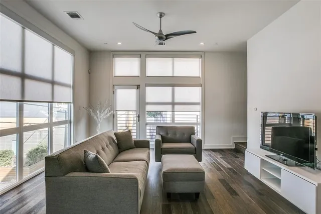 a living room with furniture a flat screen tv and a large window