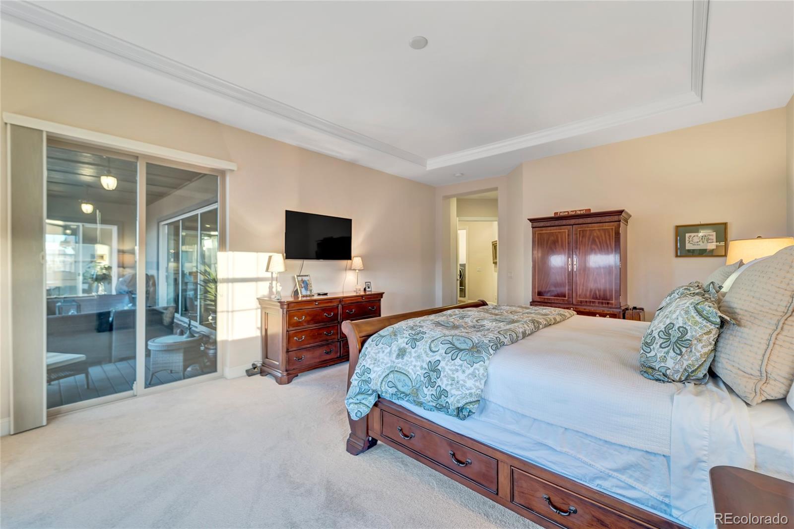 15653 Deer Mountain Circle Broomfield, CO 80023 - Photo 24 of 37 a bedroom with a large bed and a flat tv screen on dresser