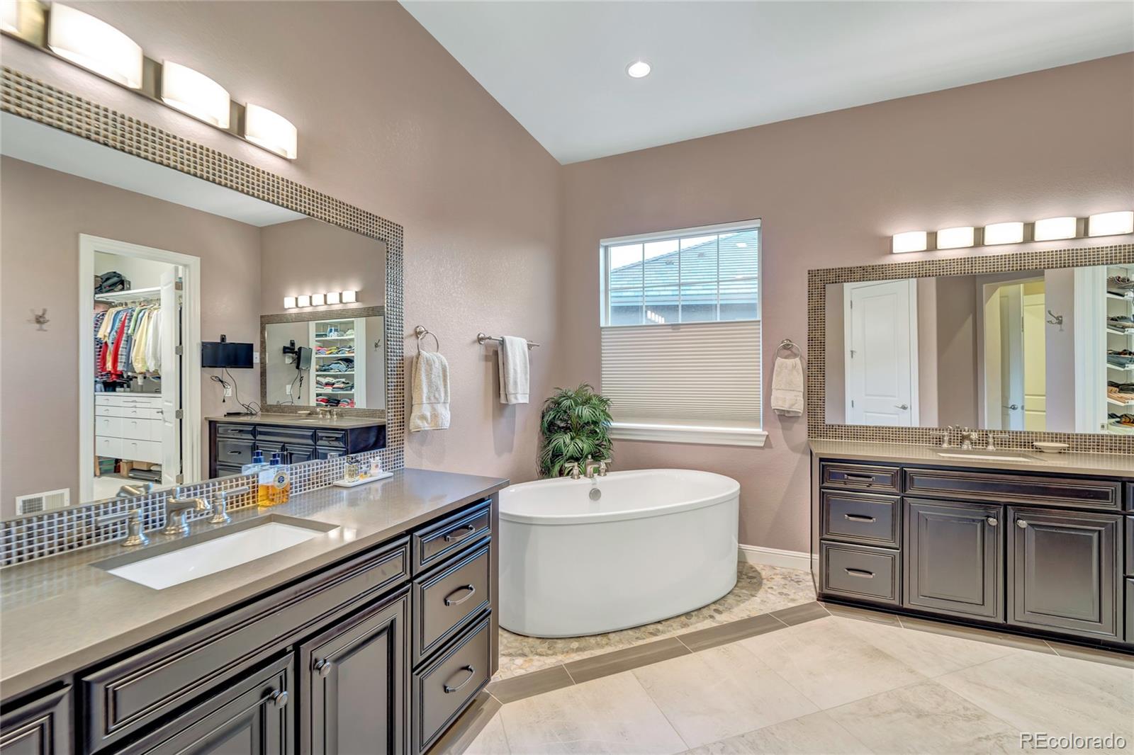15653 Deer Mountain Circle Broomfield, CO 80023 - Photo 26 of 37 a spacious bathroom with a double vanity sink a large mirror and a bathtub