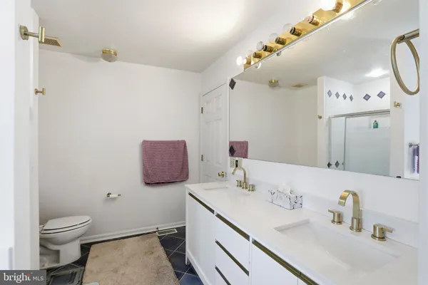 a bathroom with a sink vanity mirror and toilet