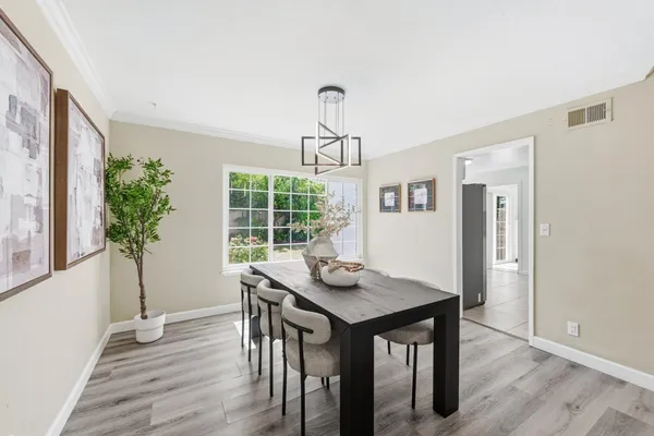 a kitchen with granite countertop a refrigerator sink and white cabinets