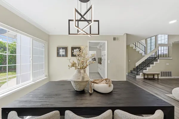 a kitchen with stainless steel appliances granite countertop a refrigerator a stove a sink and white cabinets