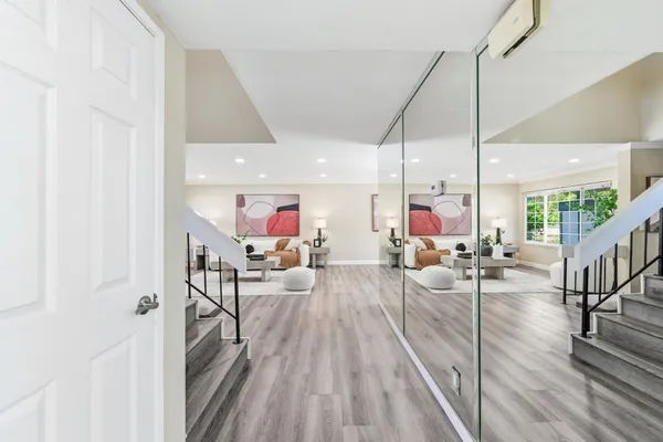 a view of a hallway with wooden floor and staircase