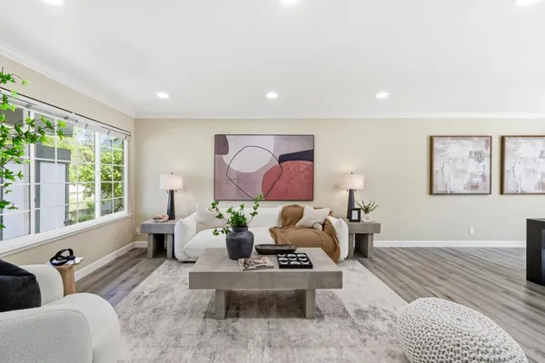a living room with furniture a potted plant and a large window