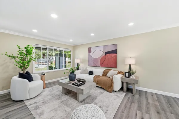 a living room with furniture flat screen tv and a large window