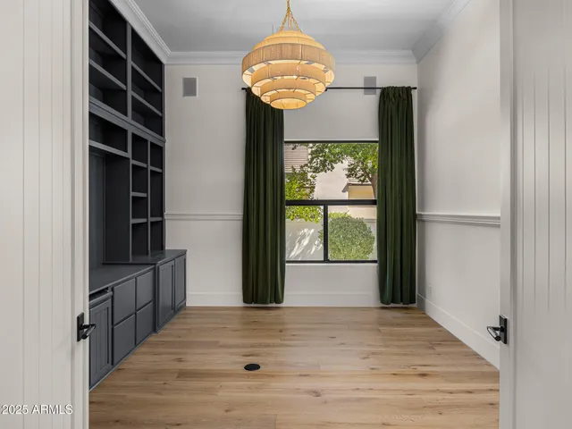 a view of hallway with wooden floor and chandelier