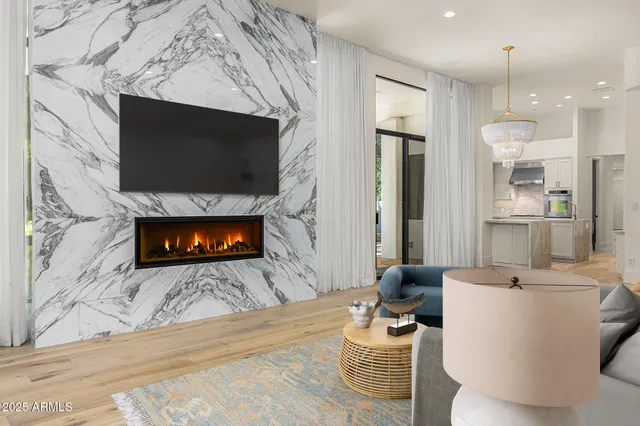 a living room with furniture a flat screen tv and a fireplace