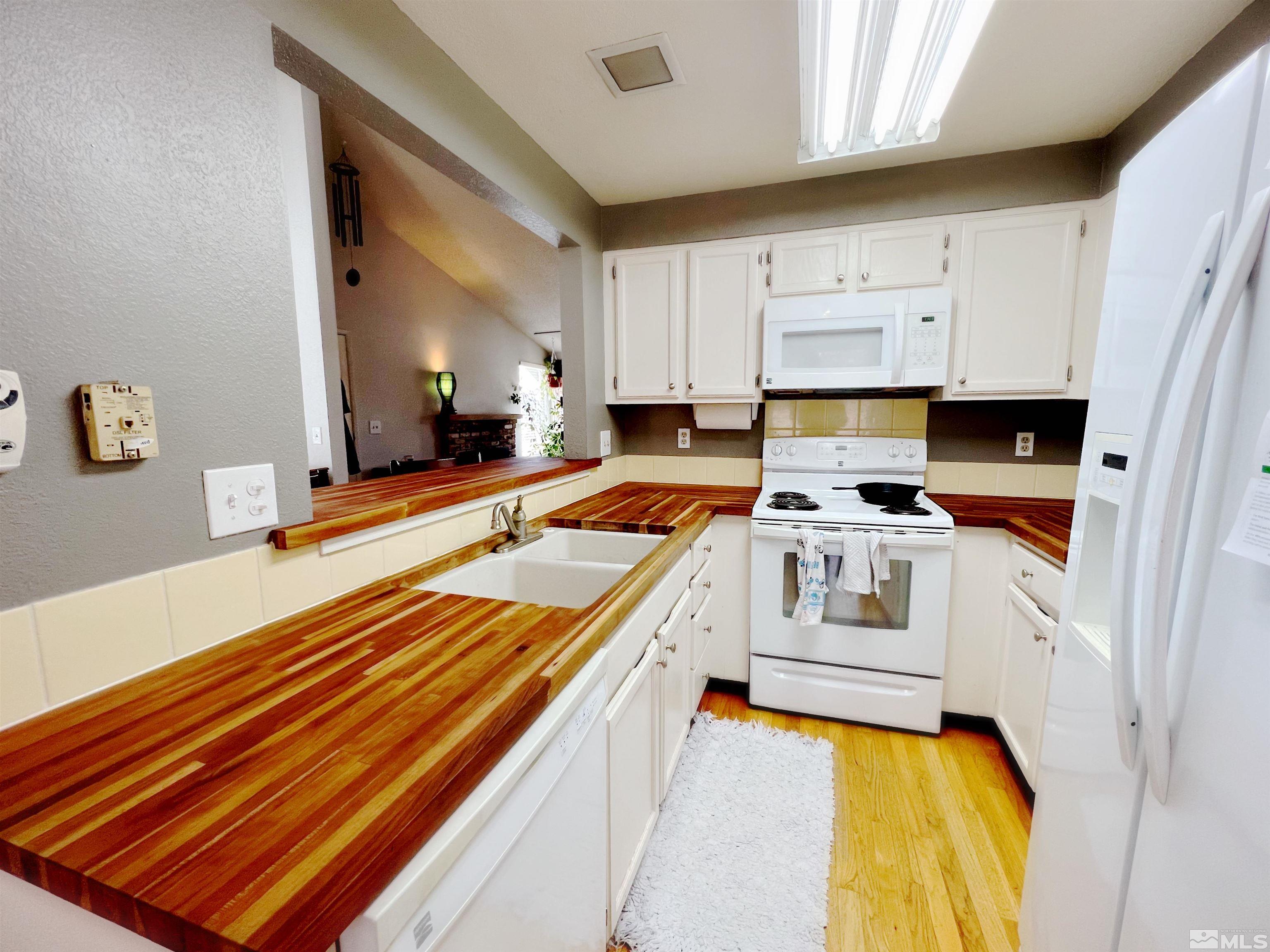 3849 Bexley Square Reno, NV 89503 - Photo 22 of 37 a kitchen with white cabinets and appliances