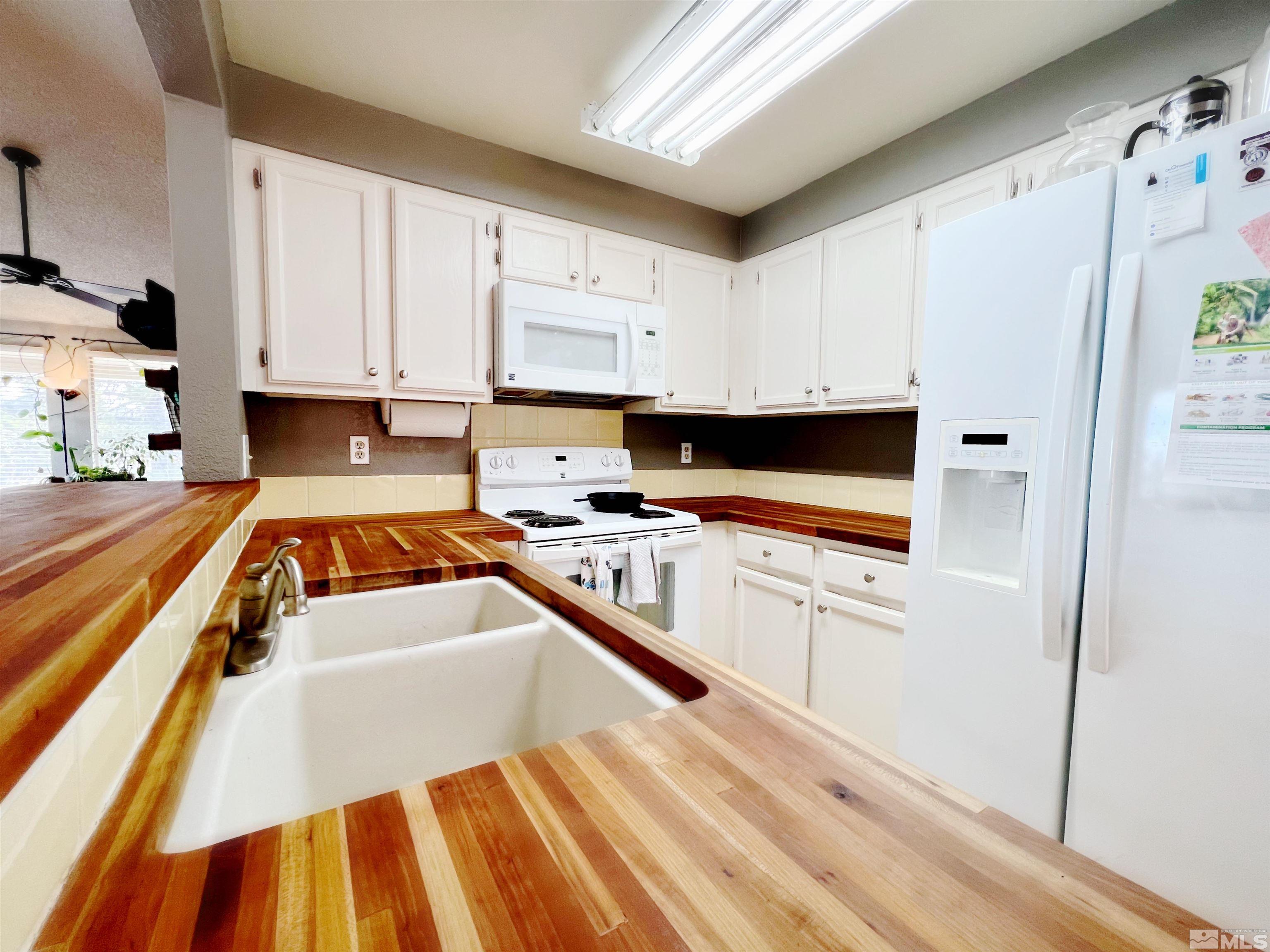 3849 Bexley Square Reno, NV 89503 - Photo 24 of 37 a kitchen with white cabinets and white appliances