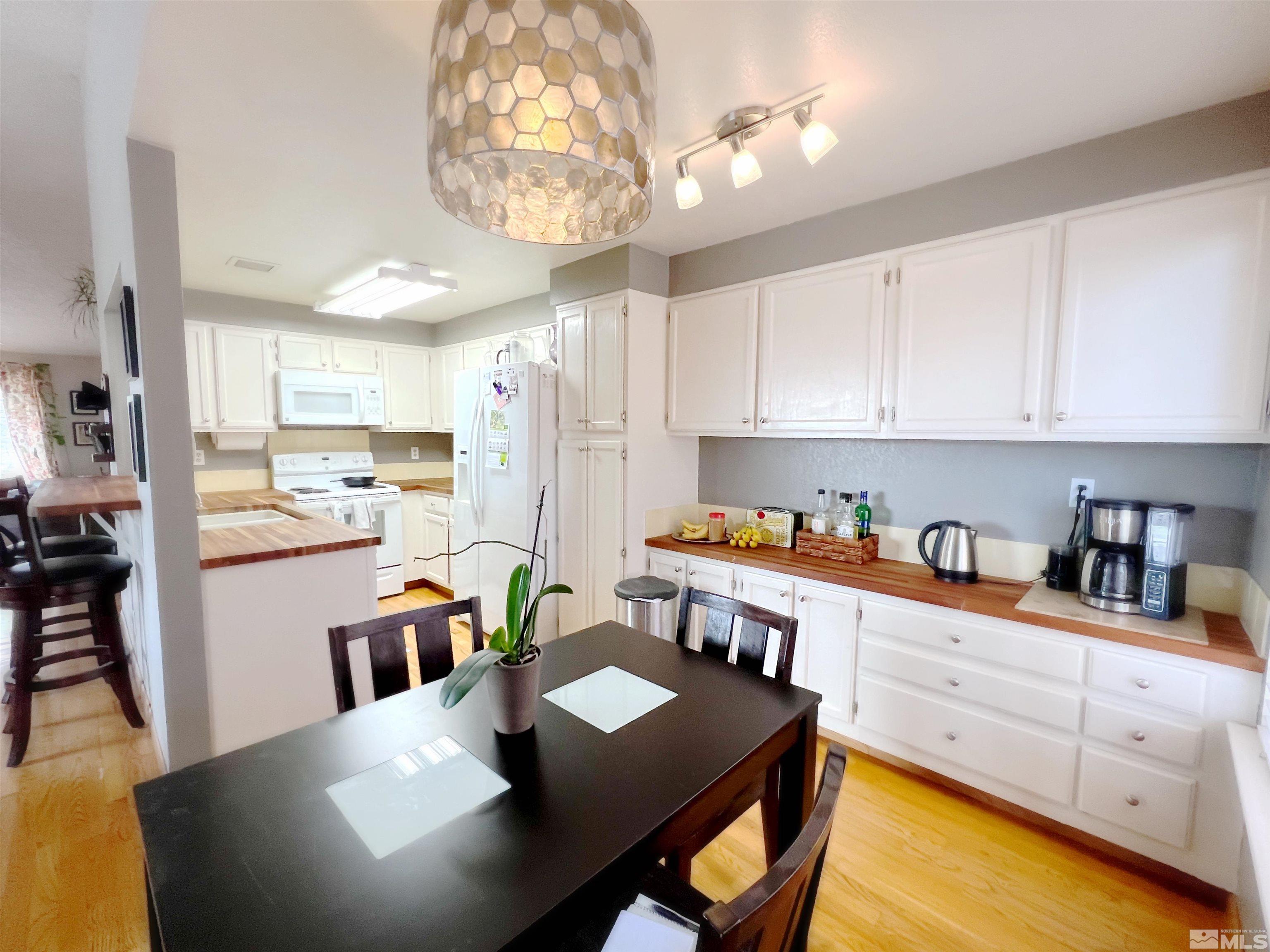 3849 Bexley Square Reno, NV 89503 - Photo 27 of 37 a kitchen with stainless steel appliances granite countertop a sink dishwasher a stove a refrigerator a microwave oven with white cabinets and wooden floor