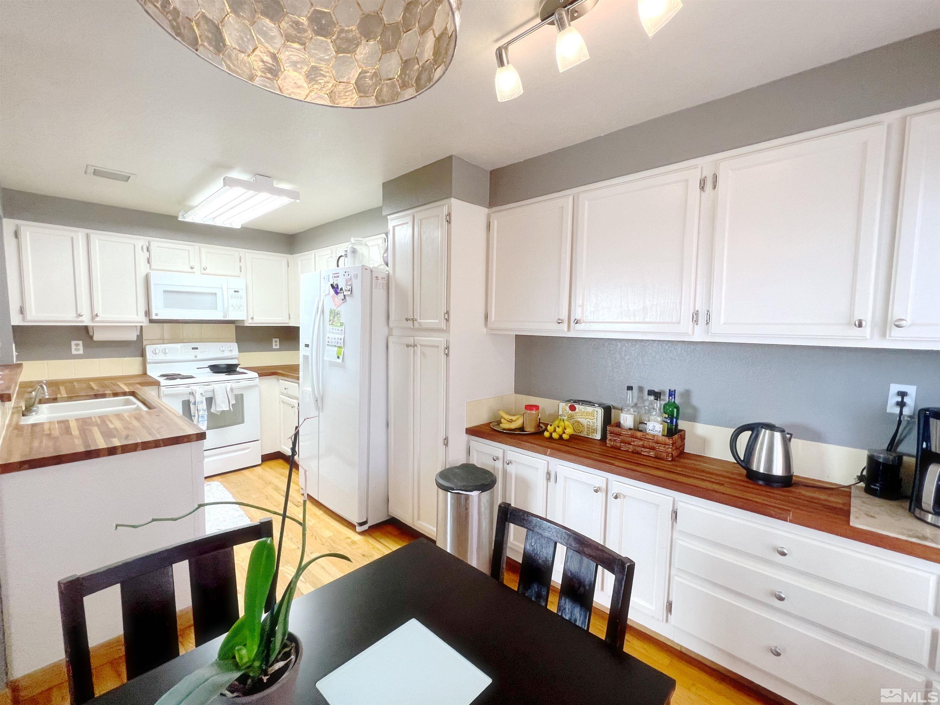 3849 Bexley Square Reno, NV 89503 - Photo 28 of 37 a kitchen with stainless steel appliances granite countertop a refrigerator a sink dishwasher a stove and white cabinets with wooden floor