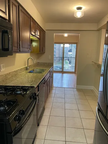 a kitchen with a stove a sink and a counter top space