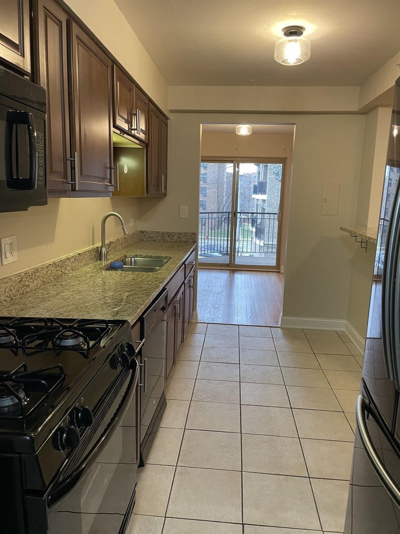 1 North Chestnut Avenue, Unit 2D Arlington Heights, IL 60005 - Photo 3 of 14 a kitchen with a stove a sink and a counter top space