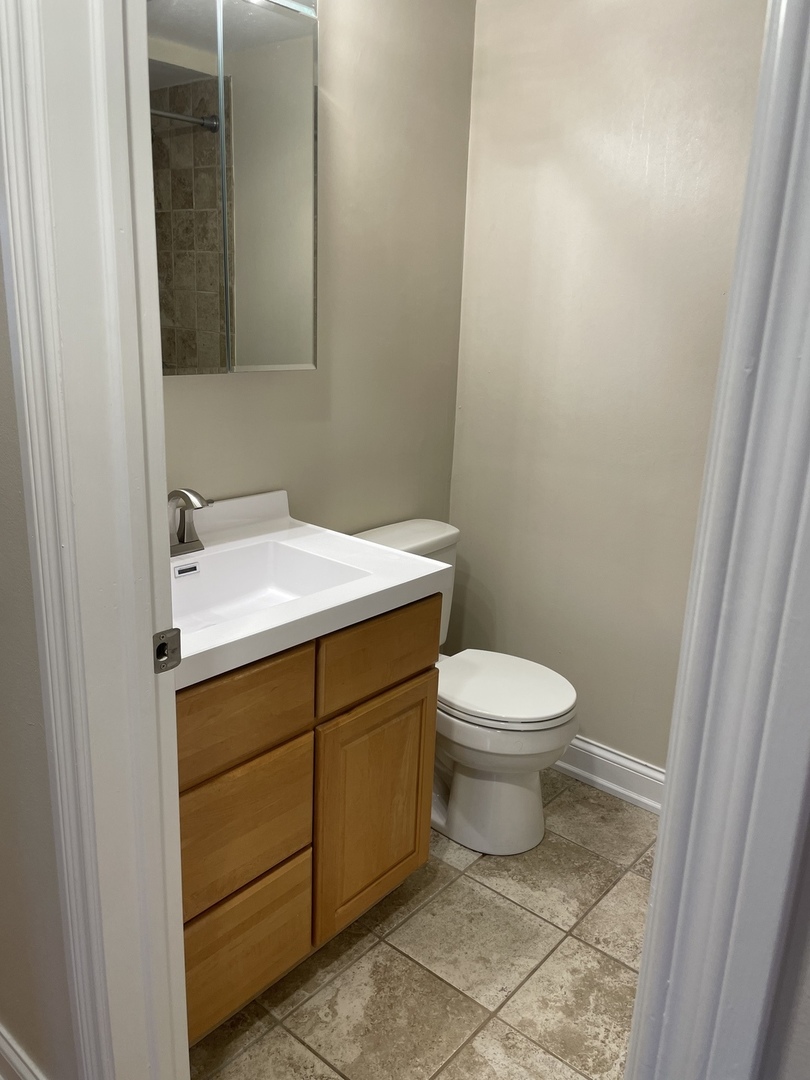 1 North Chestnut Avenue, Unit 2D Arlington Heights, IL 60005 - Photo 10 of 14 a bathroom with a toilet sink and mirror