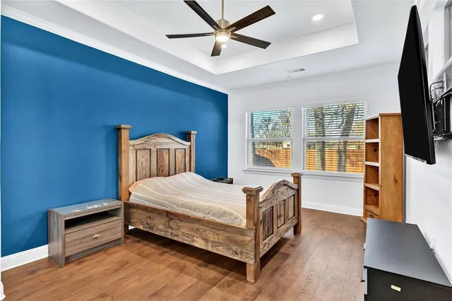 a bedroom with a bed and a flat tv screen on dresser