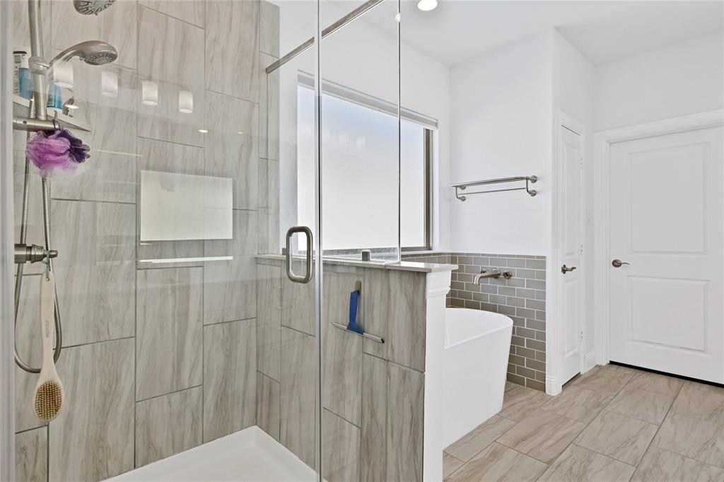 137 Gardenia Drive Azle, TX 76020 - Photo 17 of 38 Bathroom featuring a shower stall, a freestanding tub, tile walls, and wainscoting